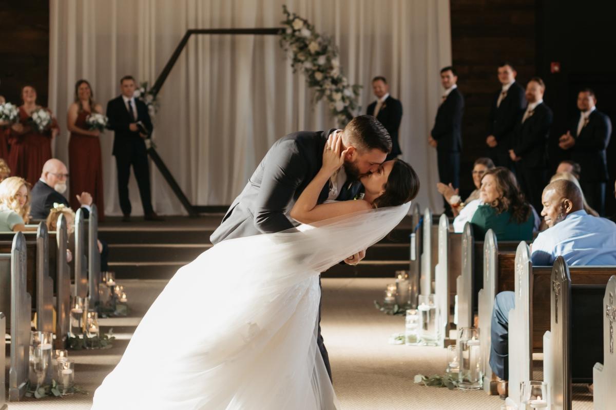 Couple kissing at wedding in indoor venue