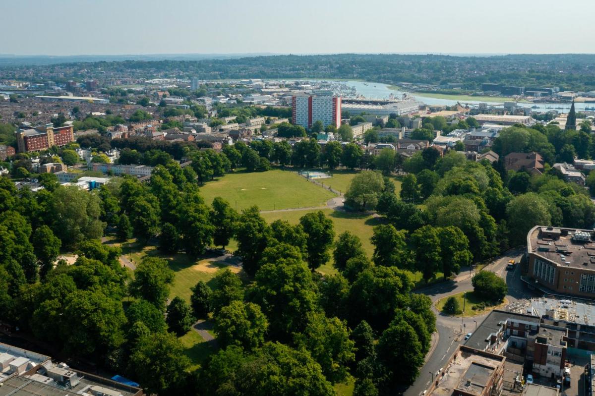 Drone shot of Southampton park full of green trees and grass