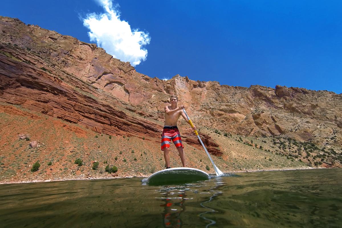 Man on SUP or Standup Paddle board at Flaming Gorge