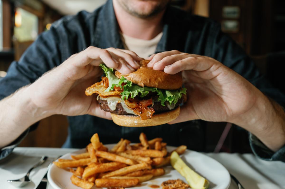 A man eating a burger at The Algonquin Restaurant