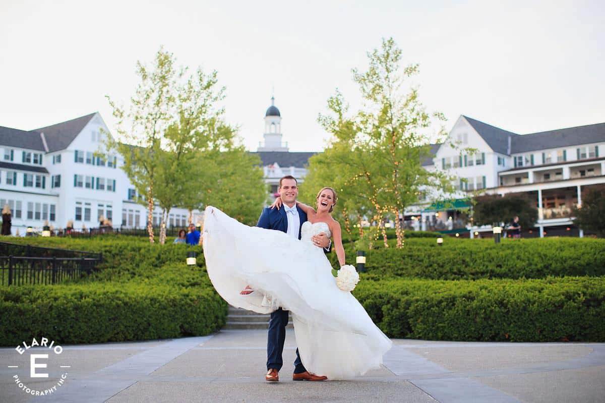 groom holding a bride in front of the Sagamore Resort