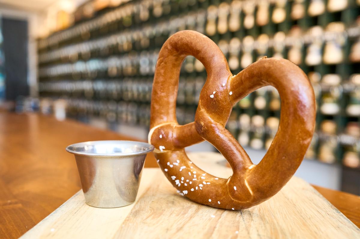 A pretzel if photographed next to a small containter of cheese at Prost in Wichita by Darrin Hackney