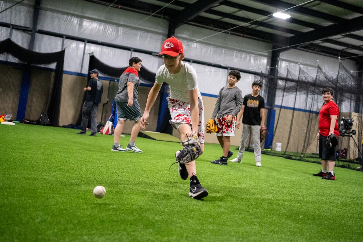 Boys play baseball inside during practice at League 42