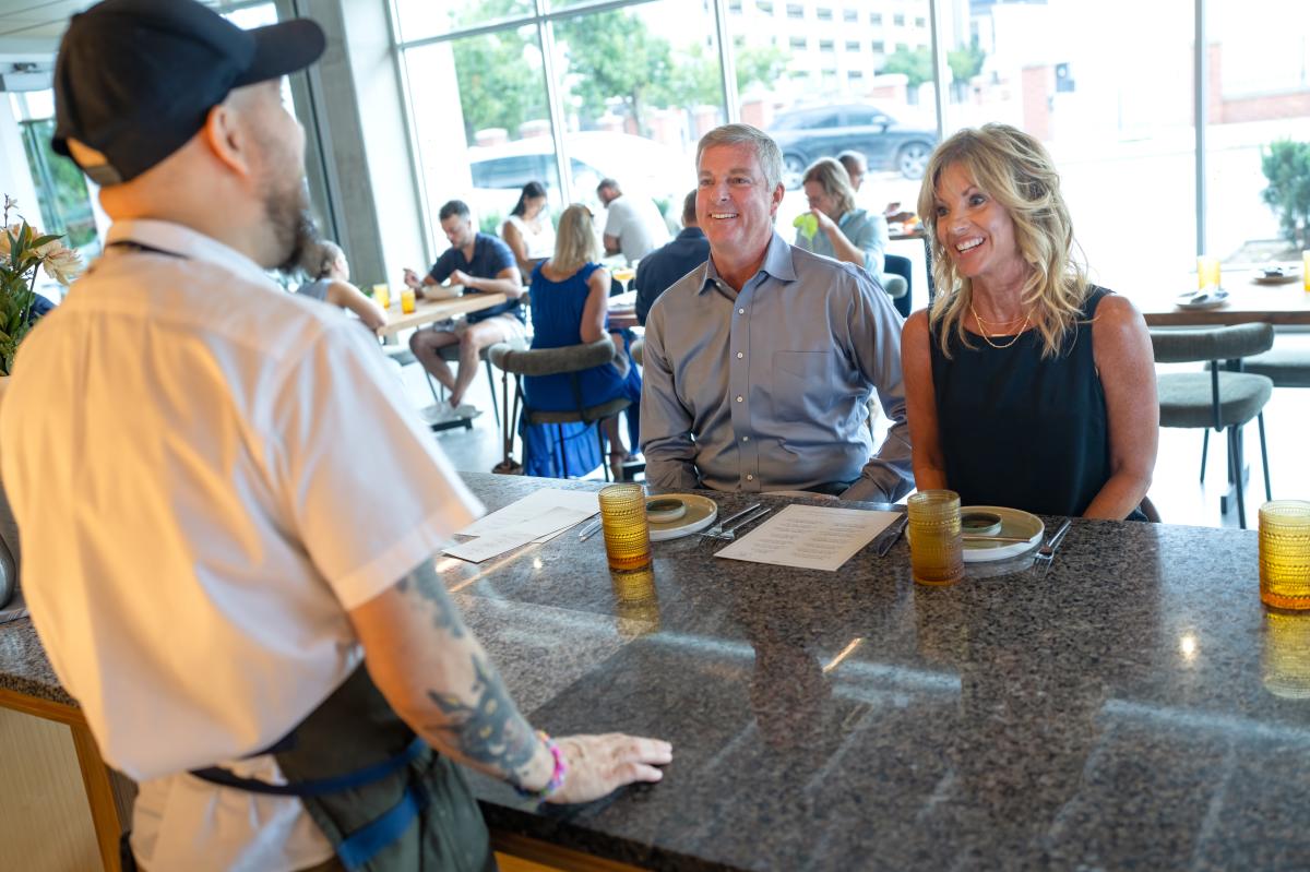 A man and woman speak to a chef at the bar while dining at Lotte in Wichita.
