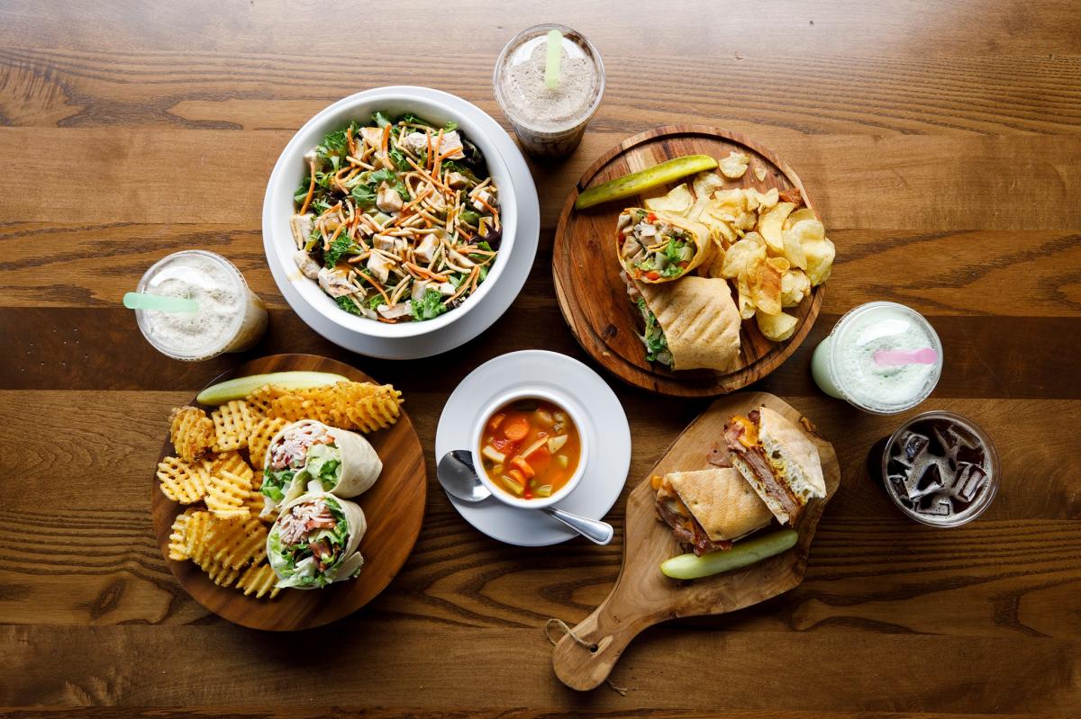 Sandwich wraps, soup, and the Asian Sesame salad at Mokas are photographed on a table