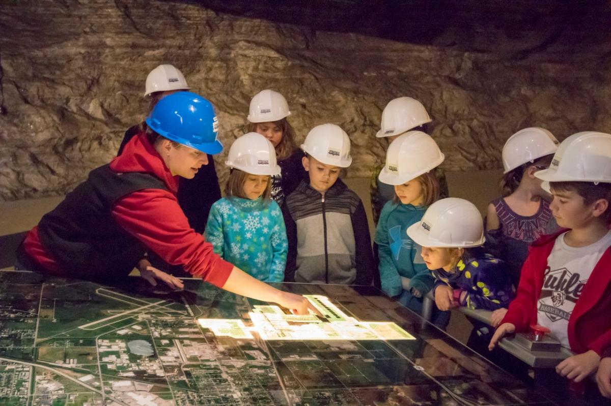 A group of children is guided on a tour of Strataca
