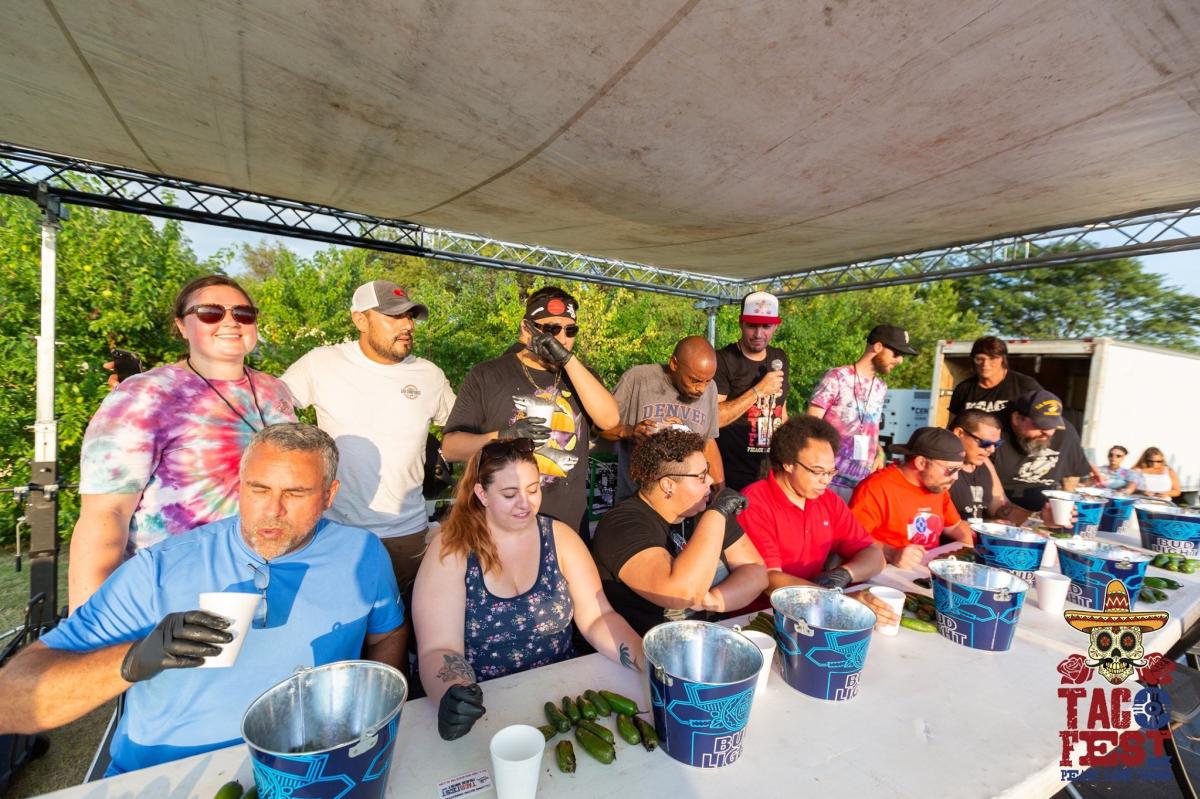 People sit at a table and compete in a jalapeno eating contest at Wichita Taco Fest