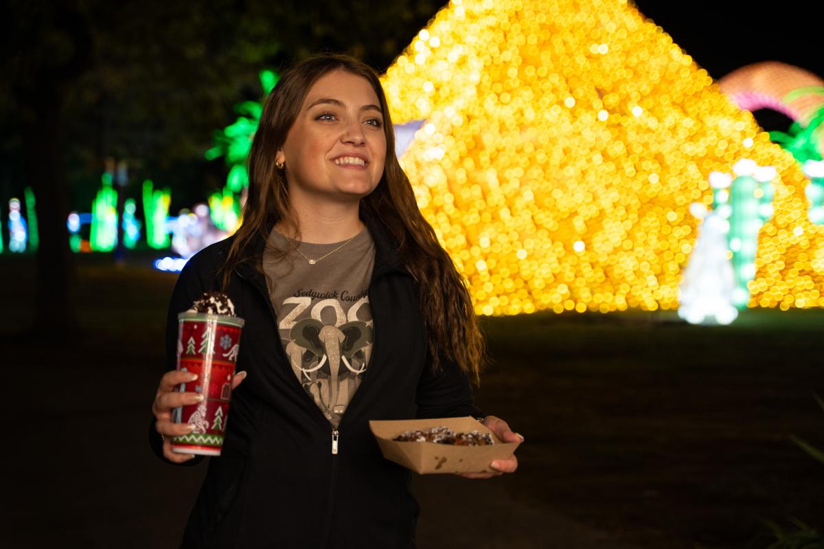 A young woman smiles while enjoying Wild Lights at Sedgwick County Zoo