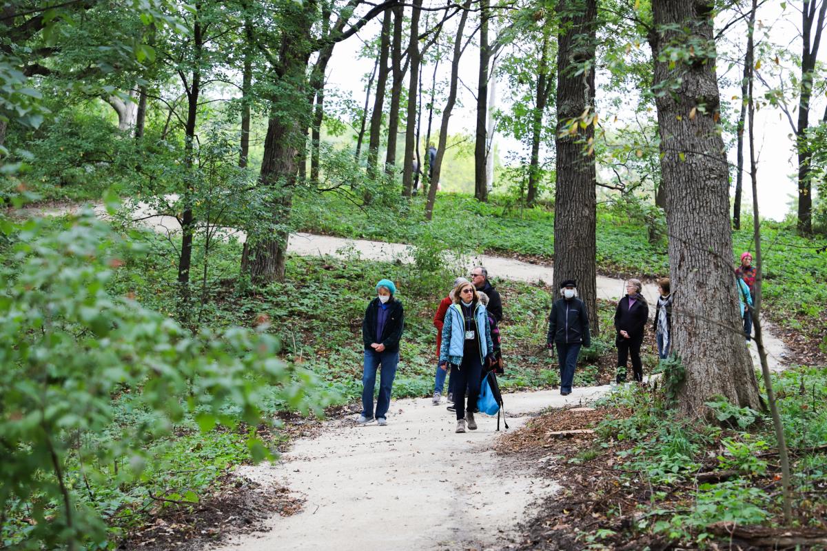 group of people hiking on a gravel trail in the woods at Emricson Park