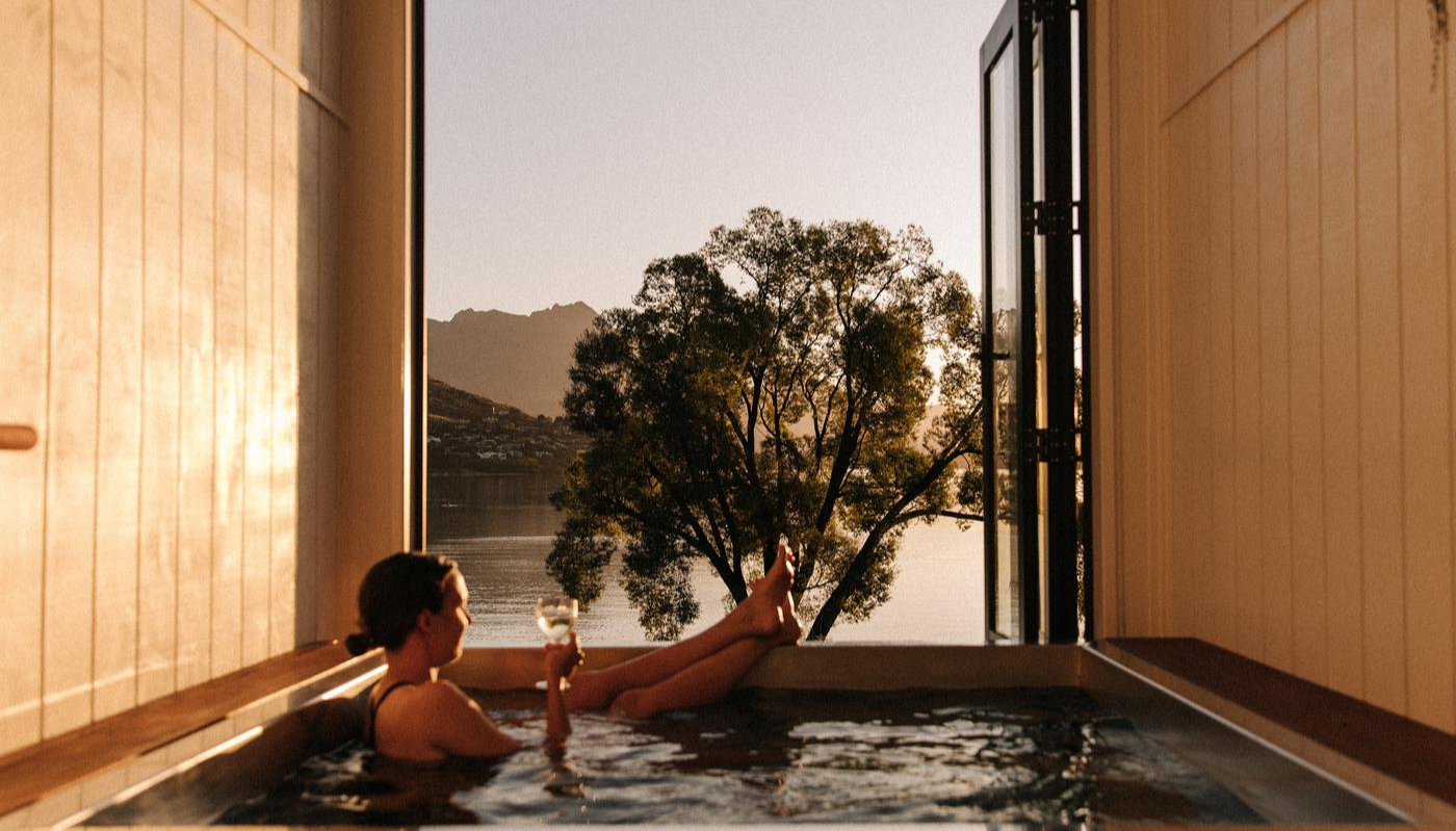 Woman relaxing with a glass of win in a hot tub at Driftaway, Queenstown