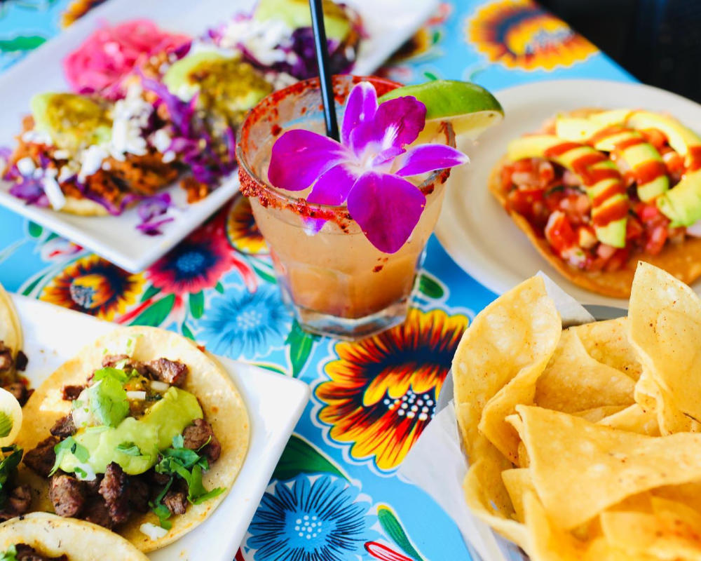 Margarita with flower and table of tacos at Gabrielas Downtown restaurant in Austin Texas