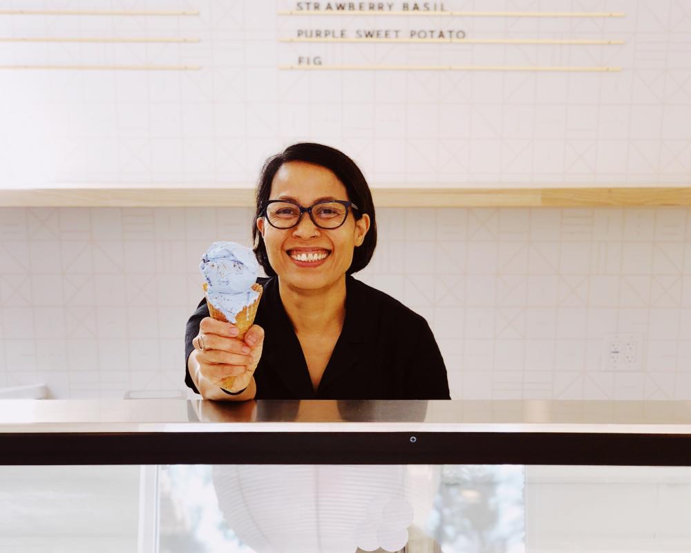 Owner Jam Sanitchat holds a double scoop cone of ice cream inside Gati