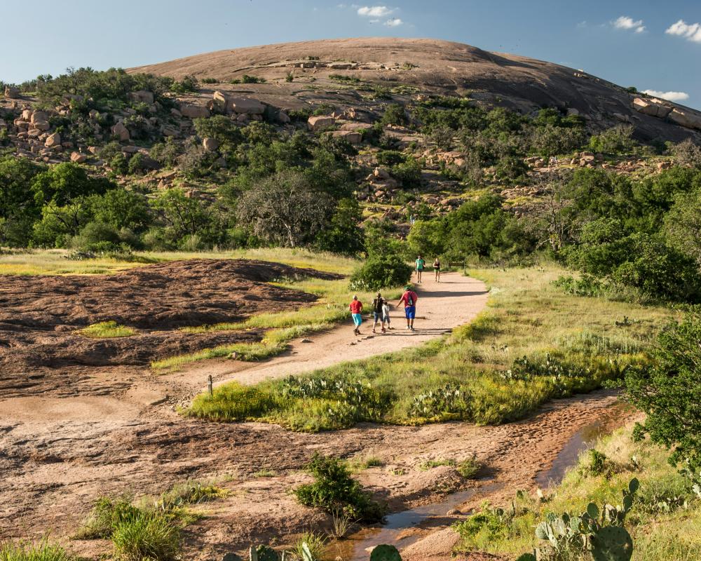 Family walking on path towards Enchanted Rock.