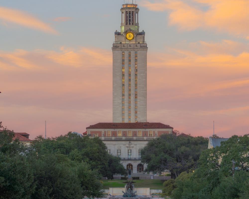 Sun setting behind the iconic UT Tower at the University of Texas at Austin.