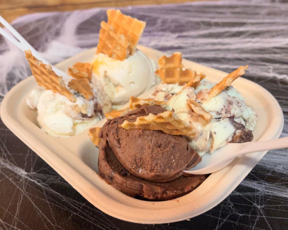 A flight made with four scoops of ice cream with waffle cone pieces.
