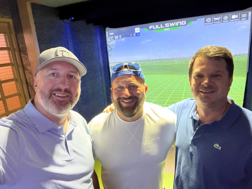 Three friends posing for a selfie at the Top Golf Swing Suite at Ameristar Casino in St. Charles, Missouri.
