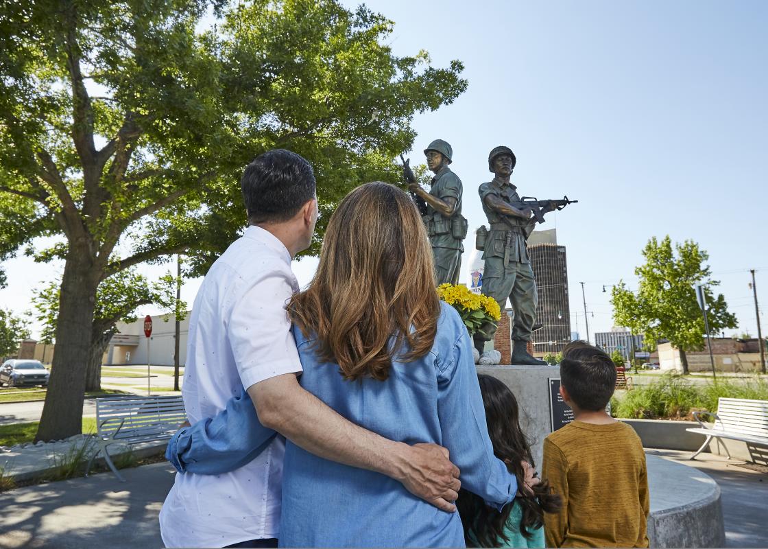 Family at looking at soldier statue at Military Park in the Asian District