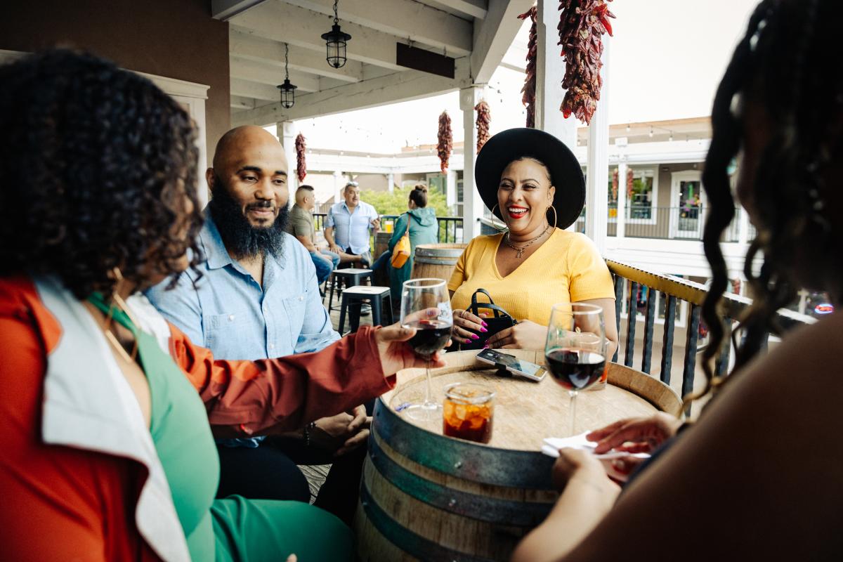 Four people sit around a table drinking wine at Downshift Brewing