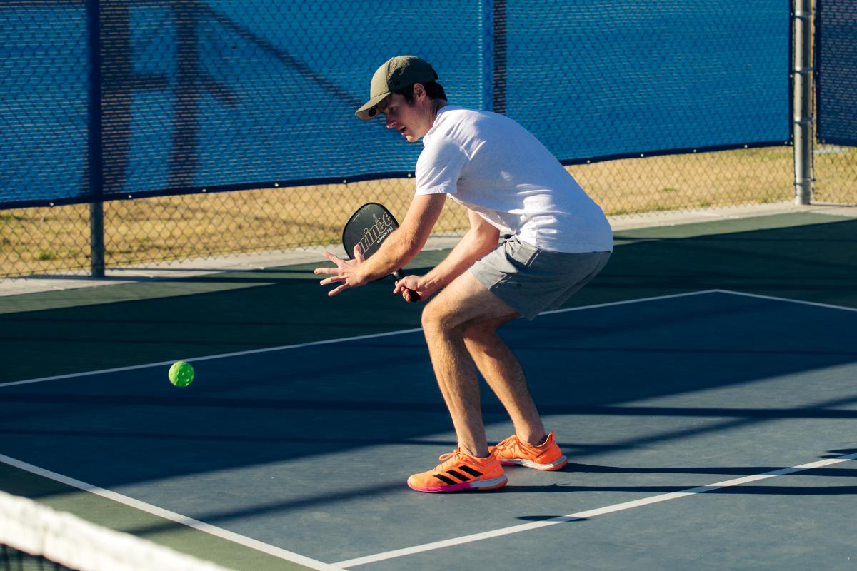 A man prepares to hit a ball while playing a game of pickleball