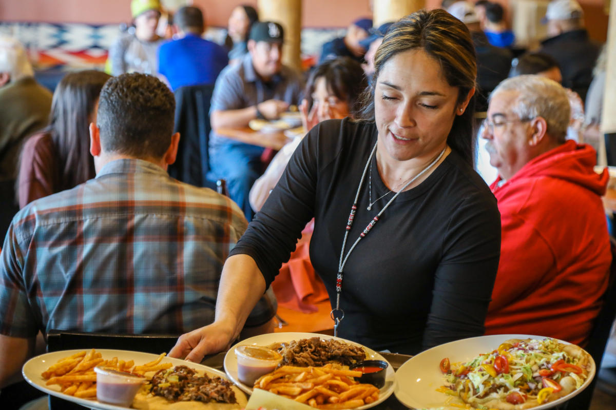 Server Shannon Rodriguez carries three plates of food at the Indian Pueblo Kitchen.