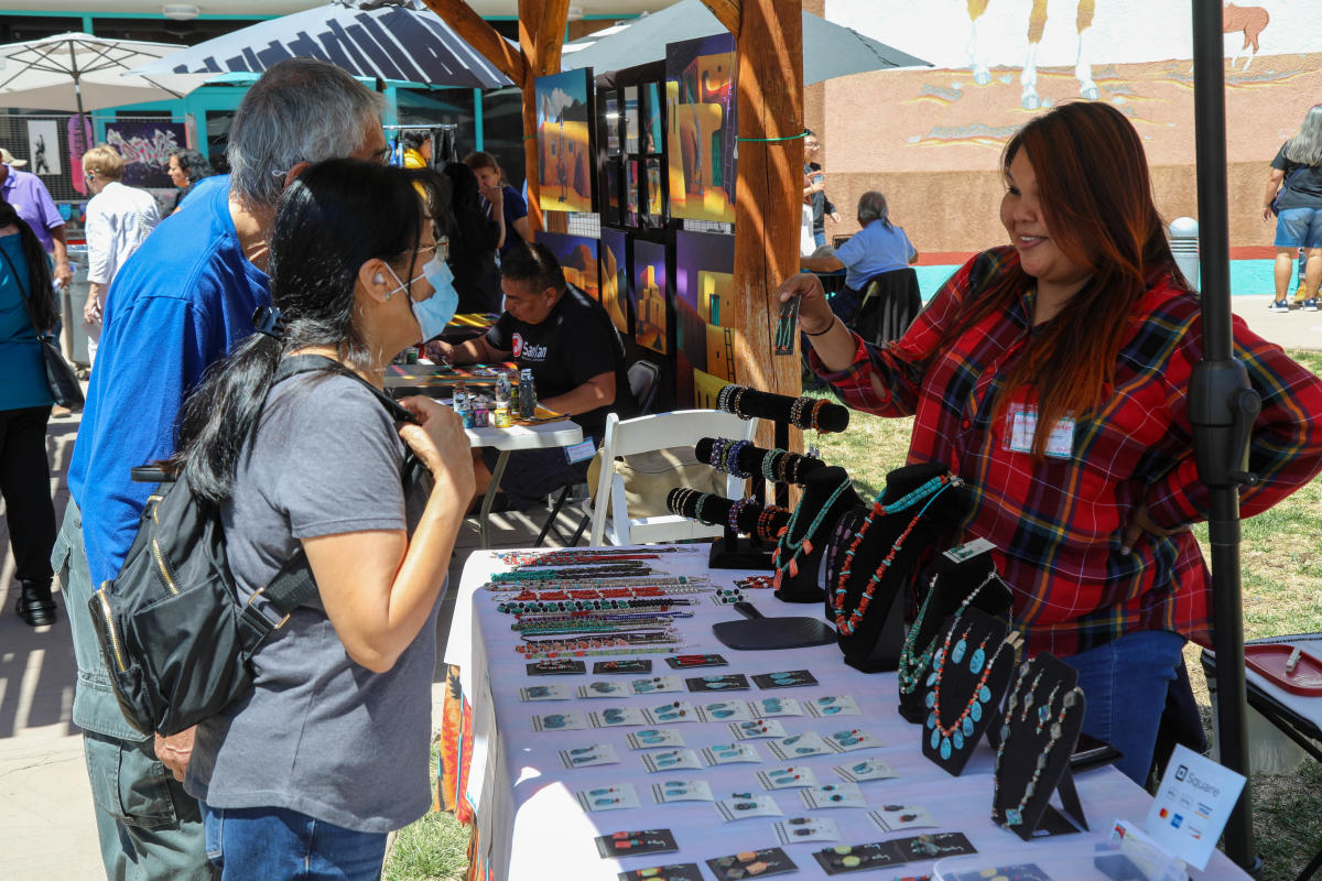 A vendor sells jewelry to visitors at the Spring Arts Market at the Indian Pueblo Cultural Center
