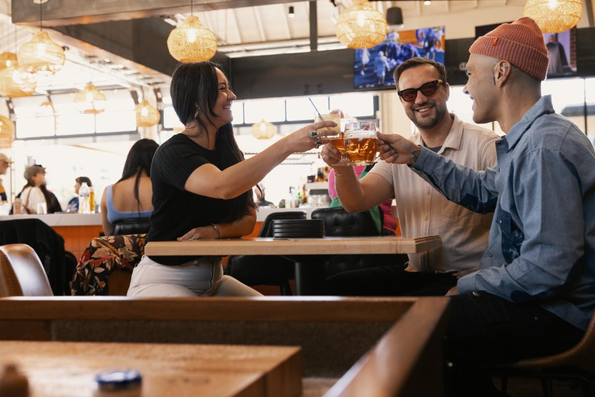 Three people cheers their beers at Ex Novo.