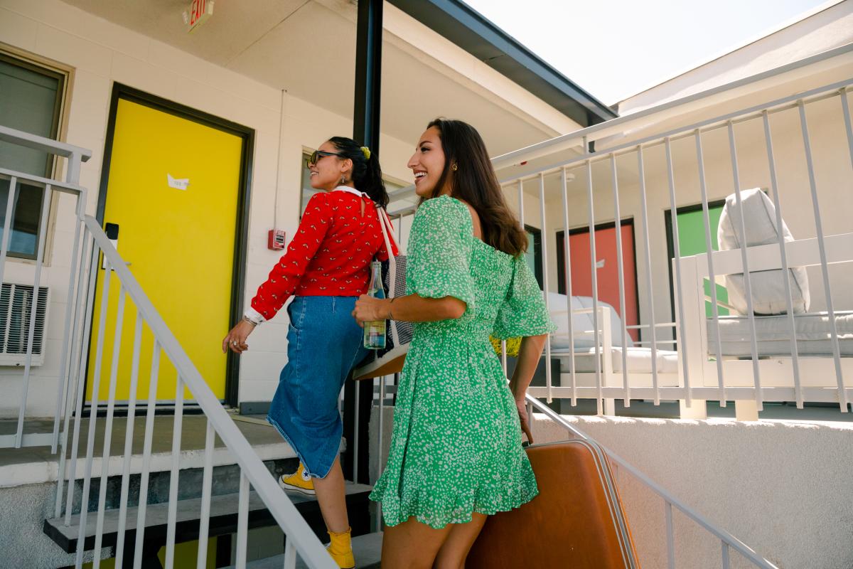 Two women walk up some stairs towards a room at the Imperial Inn.