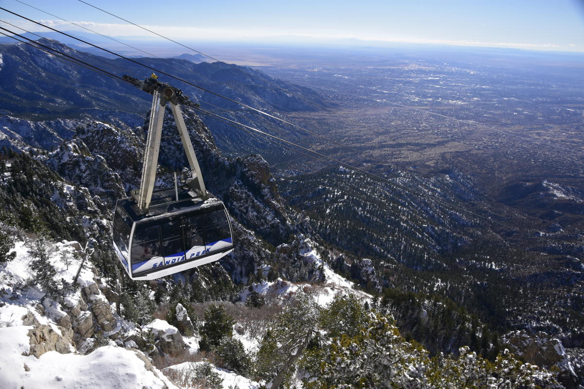 The Sandia Peak Aerial Tramway soars over the snow-covered Sandia Mountains.