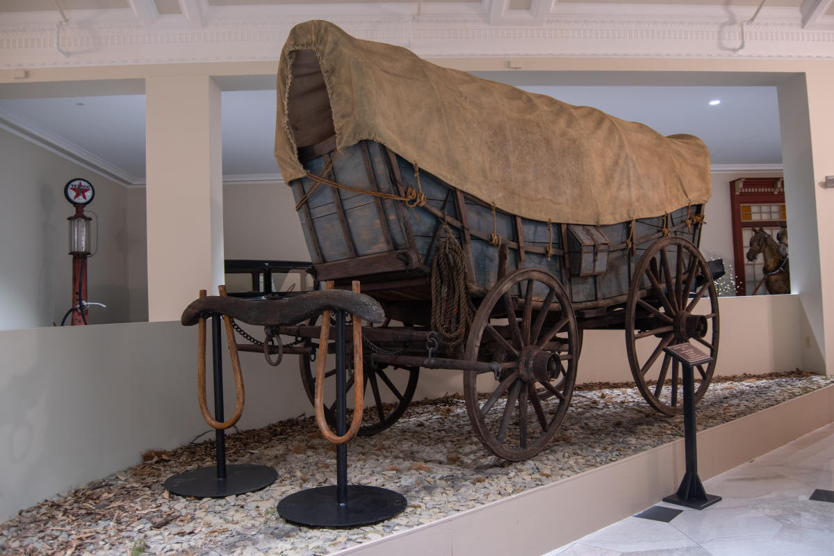 Conestoga Wagon on a gravel base on display at a museum.