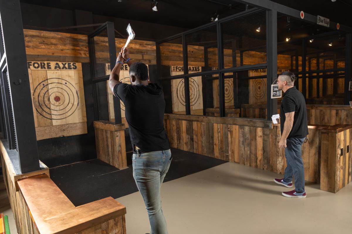 A man holds an axe ready to throw it at a target.