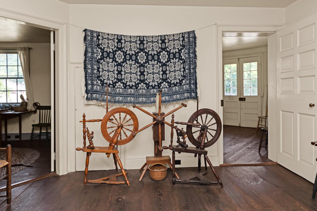 Antique spinning wheels and period furnishings inside the historic LaVale Toll House, a preserved National Road landmark in Mountain Maryland.