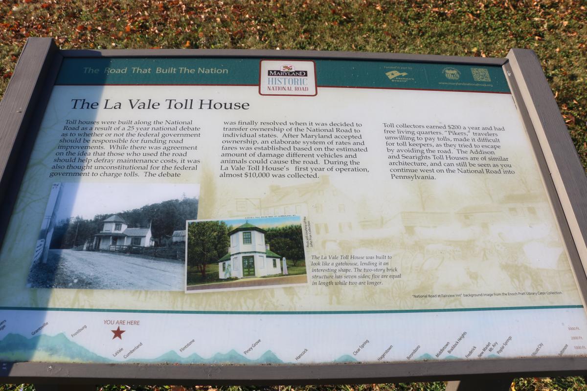 Interpretive sign at the LaVale Toll Gate House along the Historic National Road in Cumberland, Maryland, featuring historical information and images of the toll house.