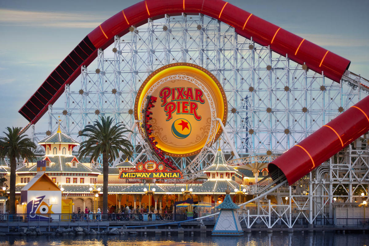Image of Pixar Pier at Disney California Adventure at night time. Featured in the photo is the Incredicoaster and Toy Story Midway Mania attractions.