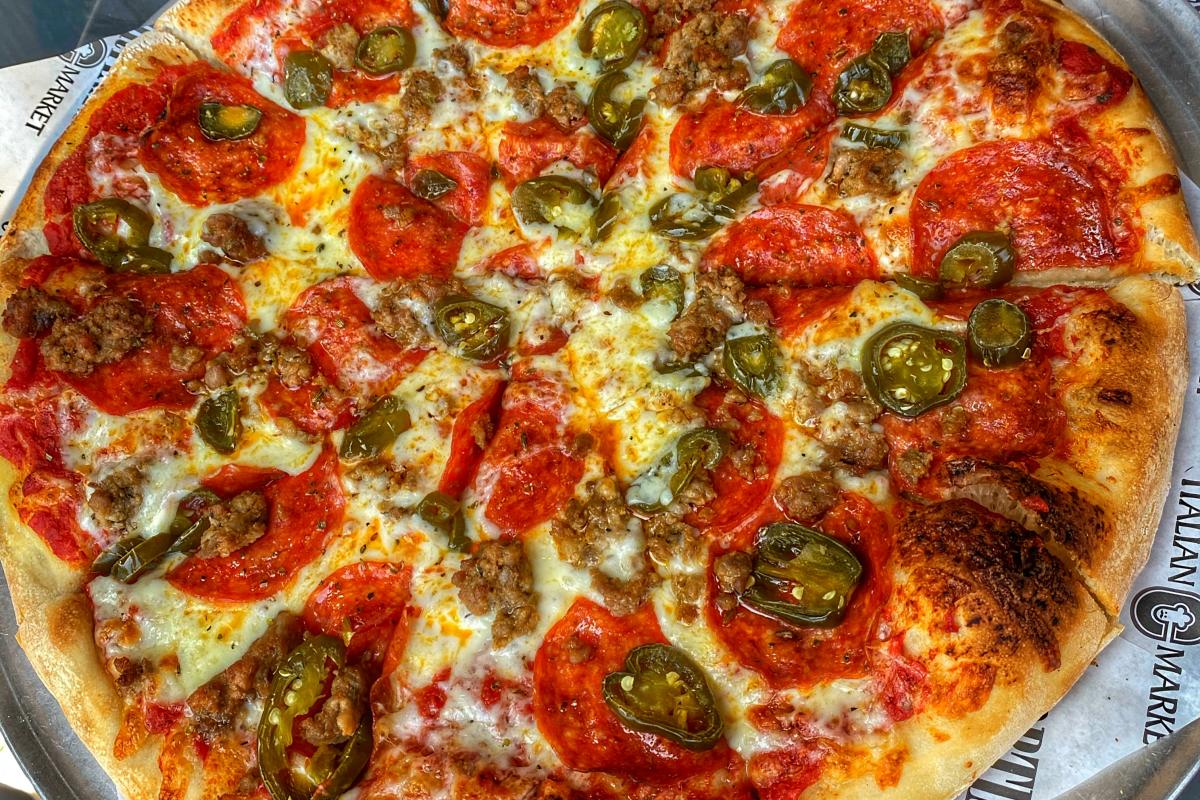 Image of pepperoni and peppers pizza, garlic bread and a sandwich from Cortina's Italian Market