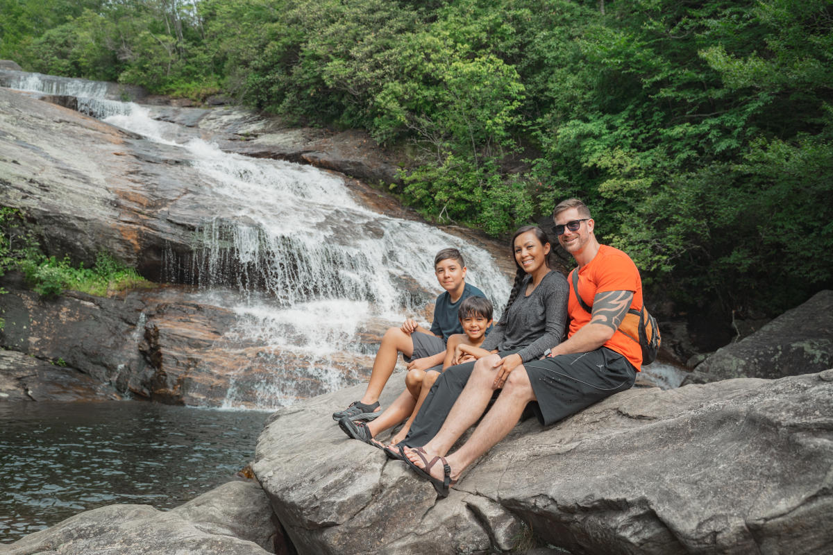 A family enjoys a stunning waterfall in the Blue Ridge Mountains near Asheville, NC