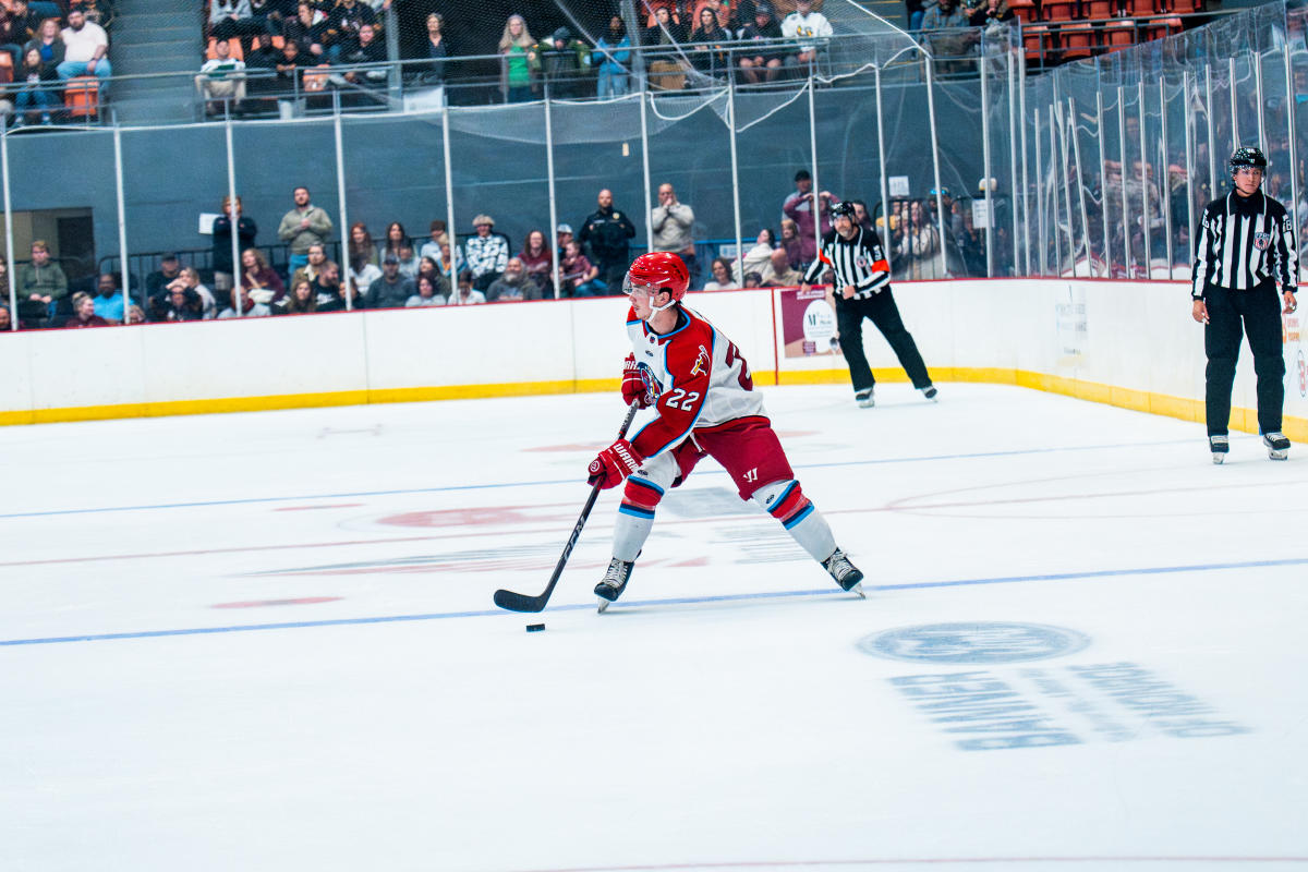 a hockey player hits the puck at a Rock Lobsters game.