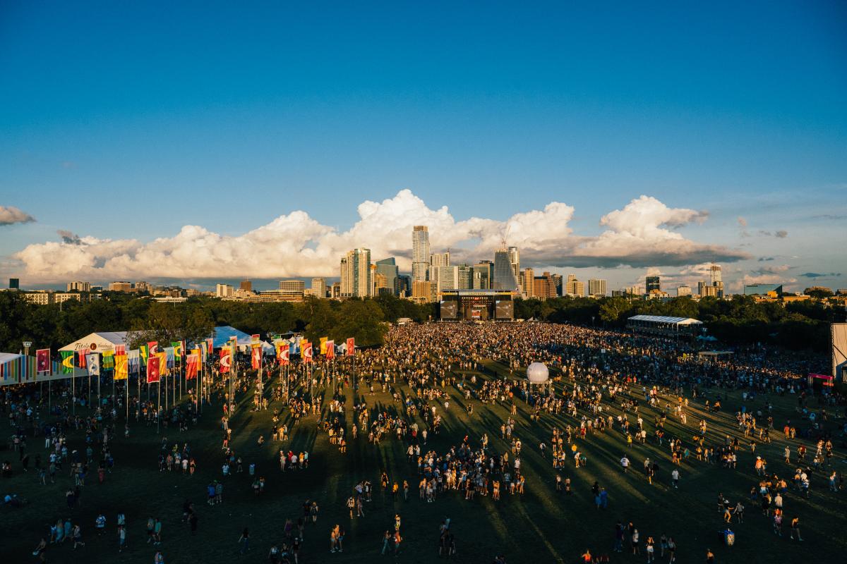 Aerial image of the main ACL Fest stage with crowds of people and the downtown skyline in the background.