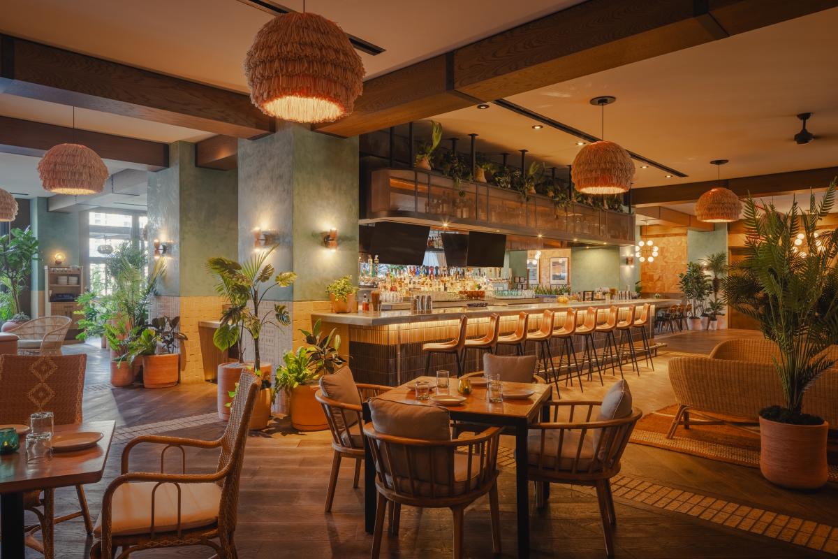 The dining room at Arriba Abajo with tables and a the bar in the background.