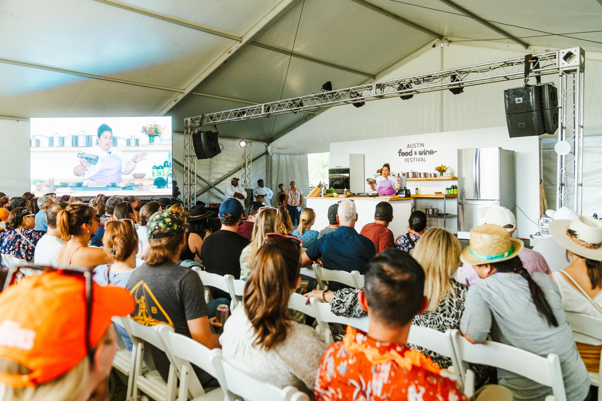 Image of a food demonstration with a chef and a room full of people watching at Austin Food & Wine Festival 2023.
