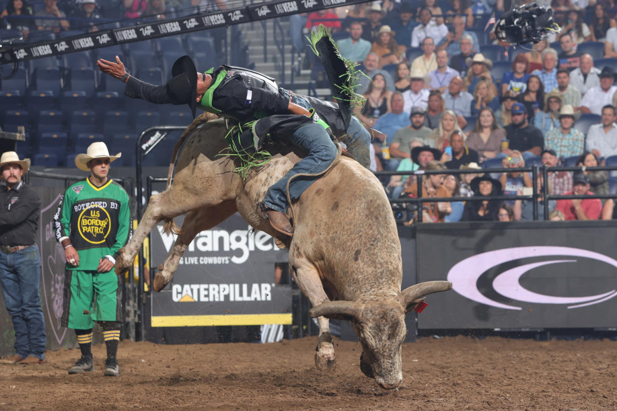 Man bull riding with bull bucking.