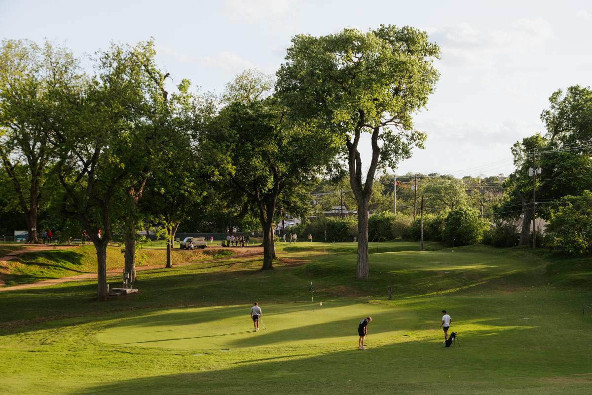 Three men playing golf at Butler Park Pitch and Putt.