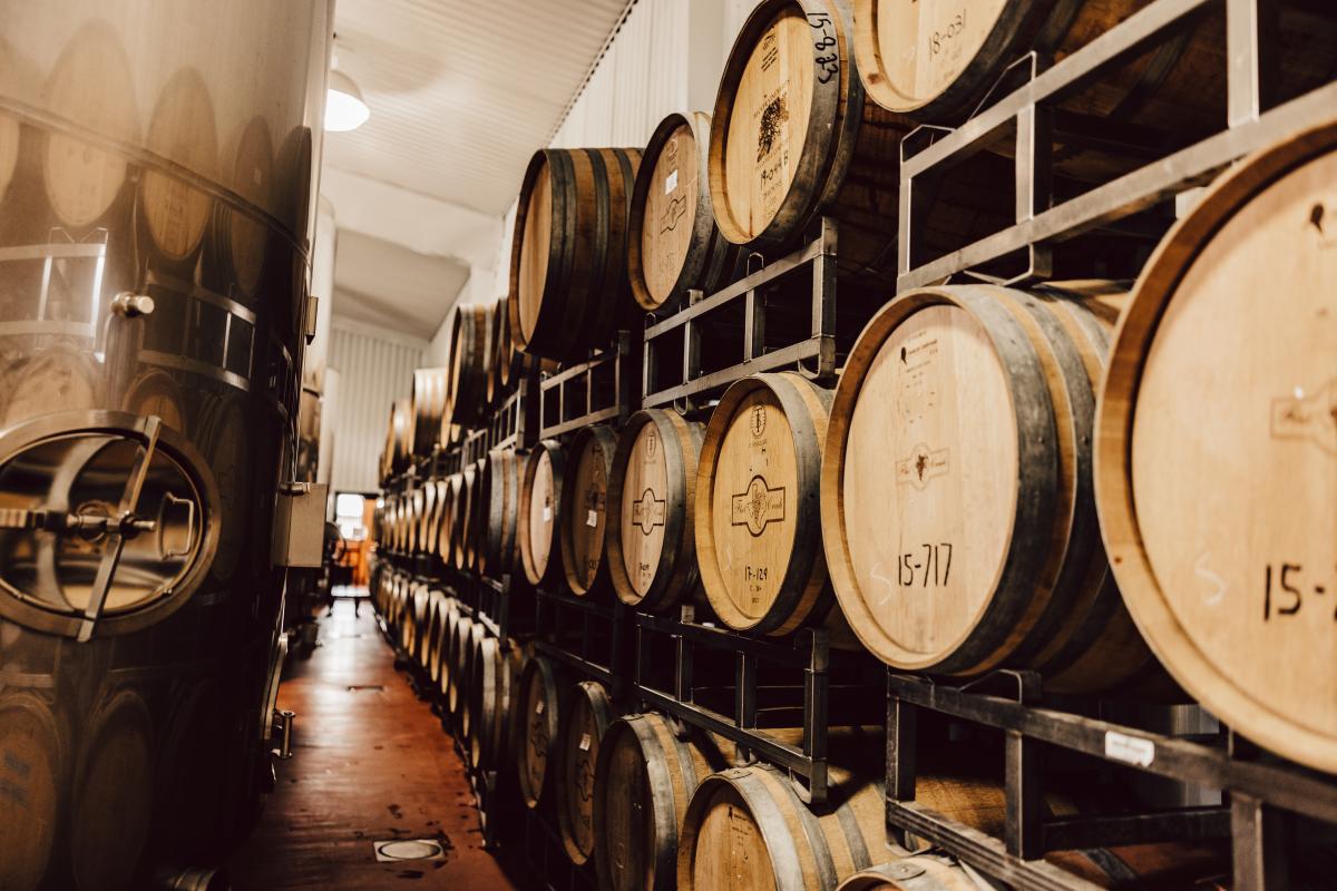 Image of wine barrels stacked up high in a back room at Flat Creek Estate Winery & Vineyard.