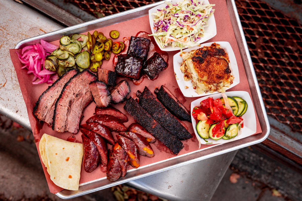 Flat lay image of a tray of barbecue including brisket, ribs, sausage and more from InterStellar BBQ.