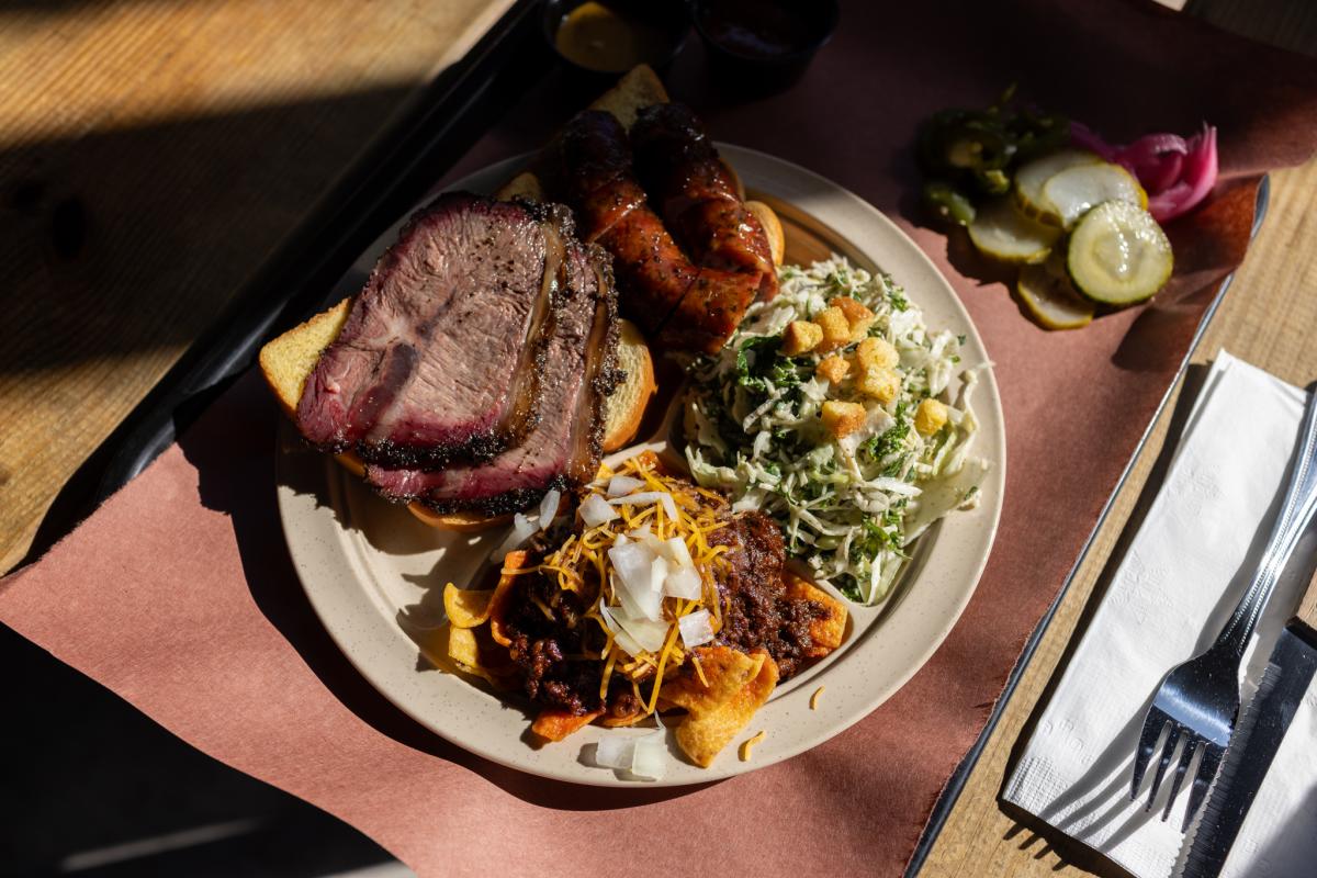 Image of a plate of barbecue and sides sitting on a tray lined with butcher paper.