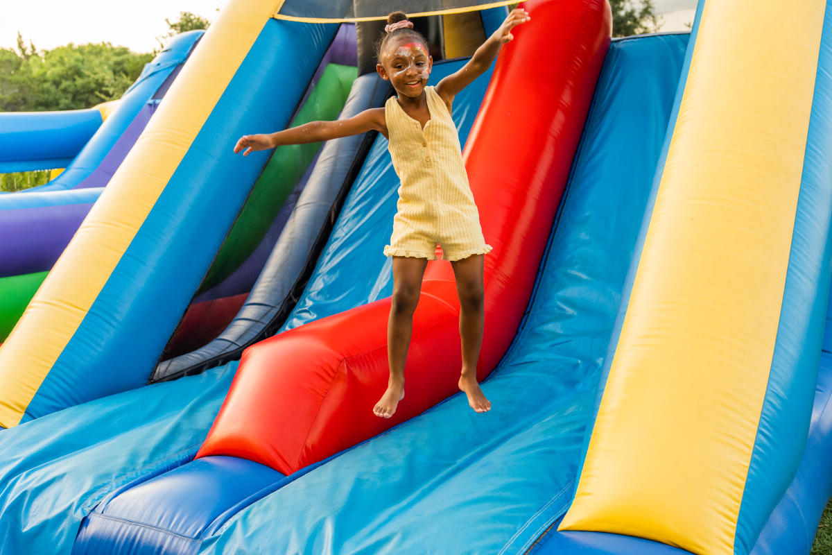 A little girl jumping on a bounce house in the Longhorn Lawn at Omni Barton Creek.