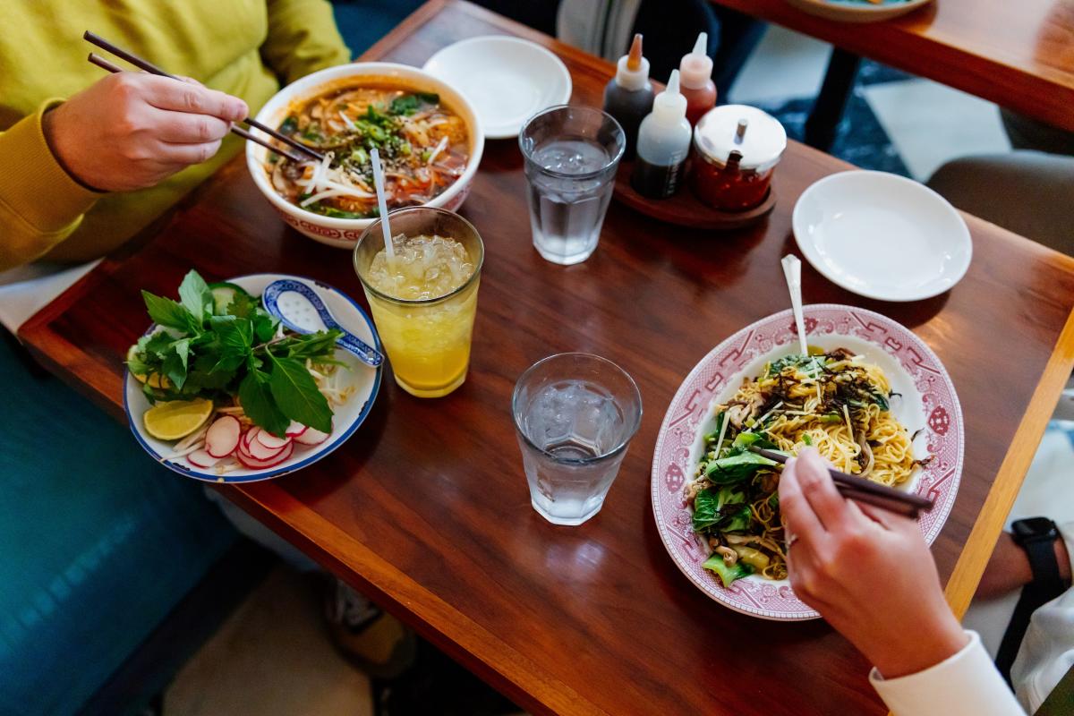 Image of two people eating Asian dishes at Elizabeth Street Cafe.