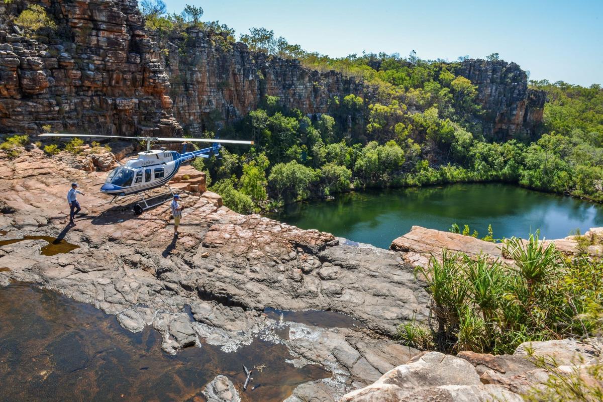 A HeliSpirit pilot and passenger explore a remote Kimberley waterfall by foot after a helicopter landing