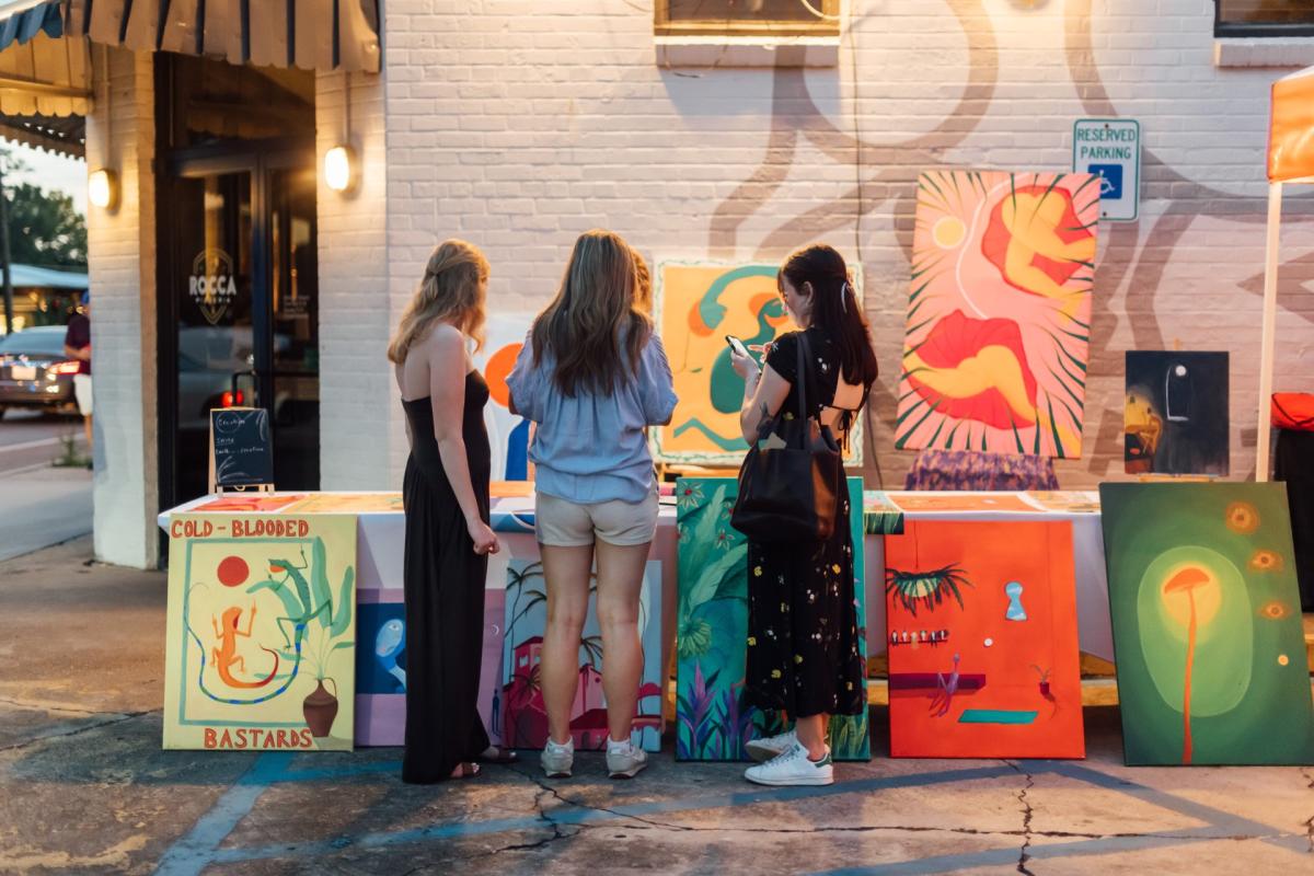Three people viewing artwork