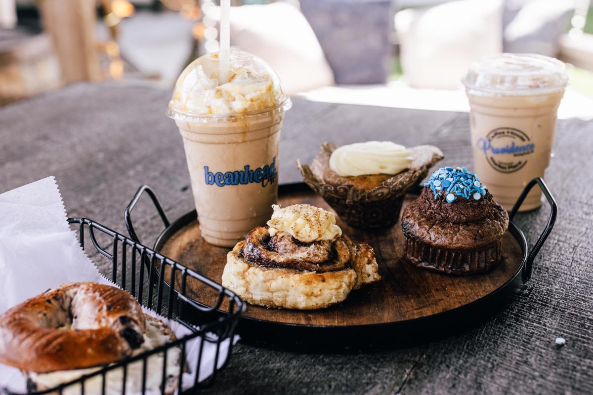 An array of assorted pastries such as bagels, cinnamon rolls and muffins as well as lattes from Providence Coffee.