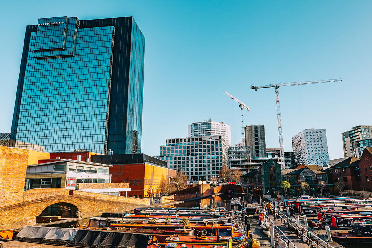 A view looking out over Regency Wharf in Birmingham, with cranes rising amidst the far building, signalling ongoing regeneration and development to the city.